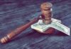 Judge's gavel resting on a stack of US dollar bills