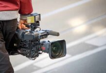camera operator carrying a professional video camera