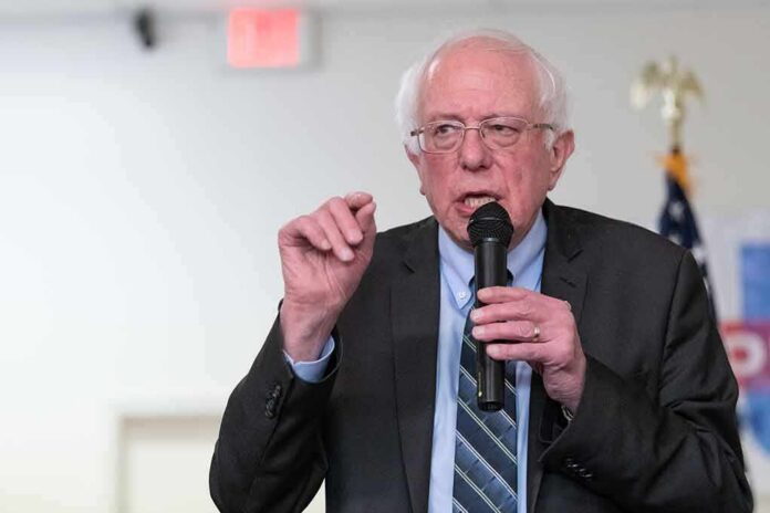 shutterstock_1324038956 Bernie Sanders speaking into a microphone at an indoor event