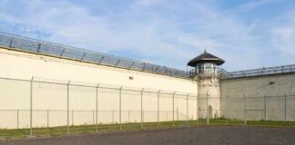 Prison yard with chain-link fence and guard tower
