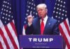 Trump Draws Line On Global Taxes man in suit speaking at podium with multiple American flags