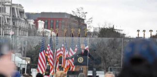 speaker at presidential podium addressing crowd outdoors