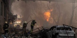 Firefighters tackle blaze amid rubble and a burned car