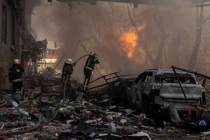 shutterstock_2148294615 Firefighters tackle blaze amid rubble and a burned car