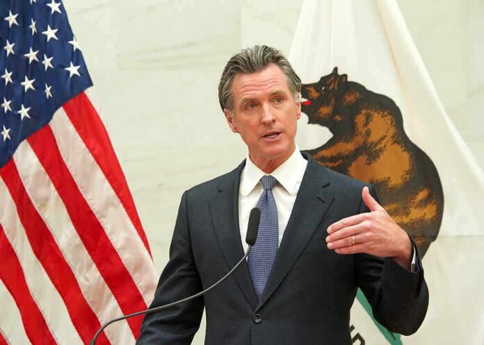 shutterstock_2150863011 Gavin Newsom speaks at a podium with U.S. and California flags behind him