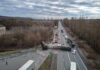 Overturned semi-trailer blocks highway at rural intersection