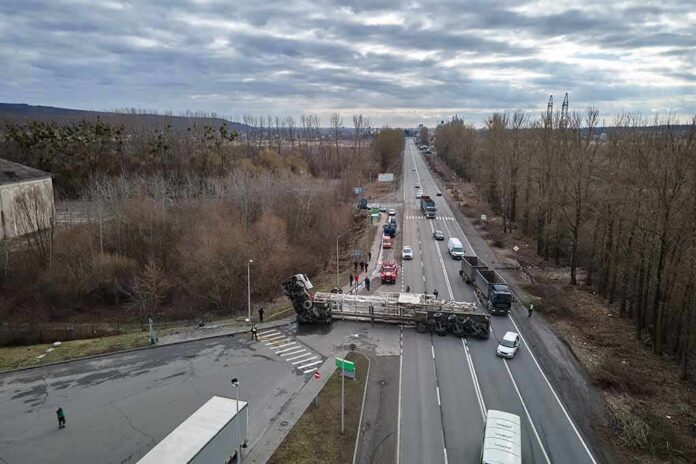 shutterstock_2154301145 Overturned semi-trailer blocks highway at rural intersection