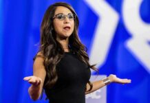 $200,000 Mystery Shadows Congressman Woman speaking on stage with arms outstretched