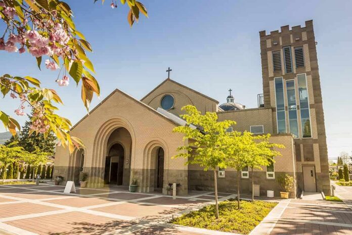 shutterstock_264314027 Brick church with arched entrance and tall bell tower on a sunny day