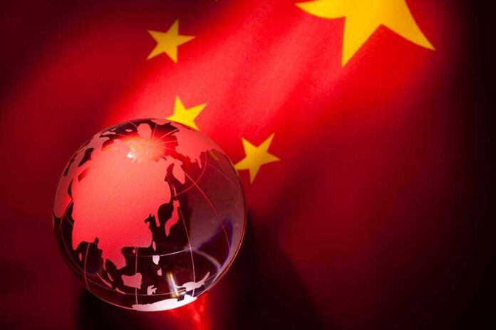 Globe,And,China,Flag,For,Background A globe illuminated against the backdrop of the Chinese flag