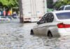 Silver car partially submerged in floodwater