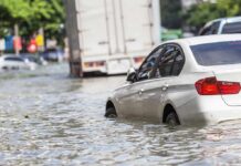 Citywide Chaos Grips Bangkok Silver car partially submerged in floodwater