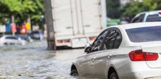 Silver car partially submerged in floodwater