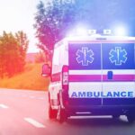 Driver Detained After Game Turns Deadly Ambulance van with flashing lights on a rural road