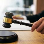 Judge Hammers Ex-Congressman Judge's hand holding a gavel over a sound block