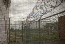 Rikers Shower Slip Triggers $1M Fight Barbed wire on chain-link fence at a prison yard