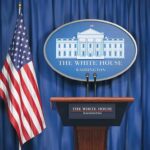 Trump’s New Enforcer Hits The Podium White House press briefing podium and US flag