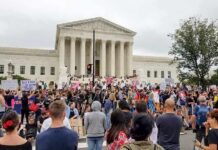 David Givens at a large protest outside a neoclassical courthouse