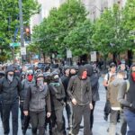 Nearly 400 Schools Go Dark group of masked protesters walking through a city street