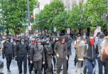Nearly 400 Schools Go Dark group of masked protesters walking through a city street