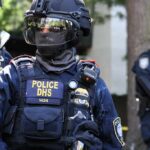 Sealed Affidavit Shadows Capitol Star Riot police officer in tactical gear with helmet and visor
