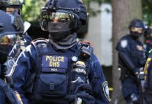 Sealed Affidavit Shadows Capitol Star Riot police officer in tactical gear with helmet and visor