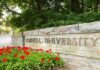 Cornell Case Takes Dramatic New Turn Cornell University stone entrance sign with red flowers