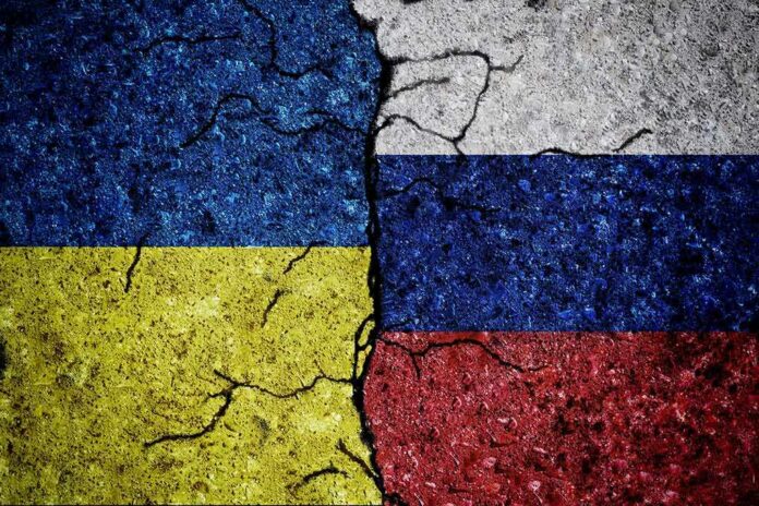 Ukraine and Russia flags divided by cracked line