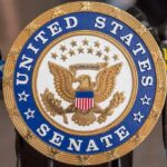 Senator Demands Signature Scalp Cases United States Senate seal at a podium