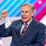 Texas Scores Gigantic DHS Payout man in suit speaking on stage with raised fist