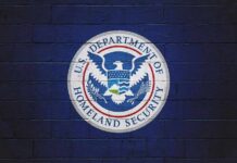 New Details Emerge In Omar Immigration Probe U.S. Department of Homeland Security seal on a blue brick wall