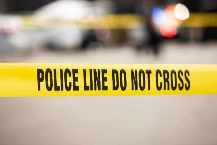 shutterstock_2281976347 Yellow police tape reading 'POLICE LINE DO NOT CROSS' at a cordoned area