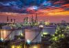 G7 Unleashes 100 Million Oil Barrels Oil refinery with storage tanks at sunset