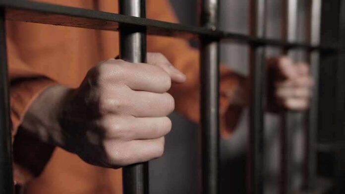 hands gripping prison bars