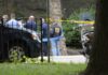 law enforcement officers gather at taped-off outdoor scene