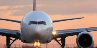 Front view of a commercial airplane on runway at sunset