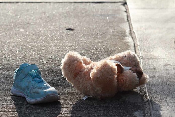 Teddy bear and single blue sneaker on a sidewalk
